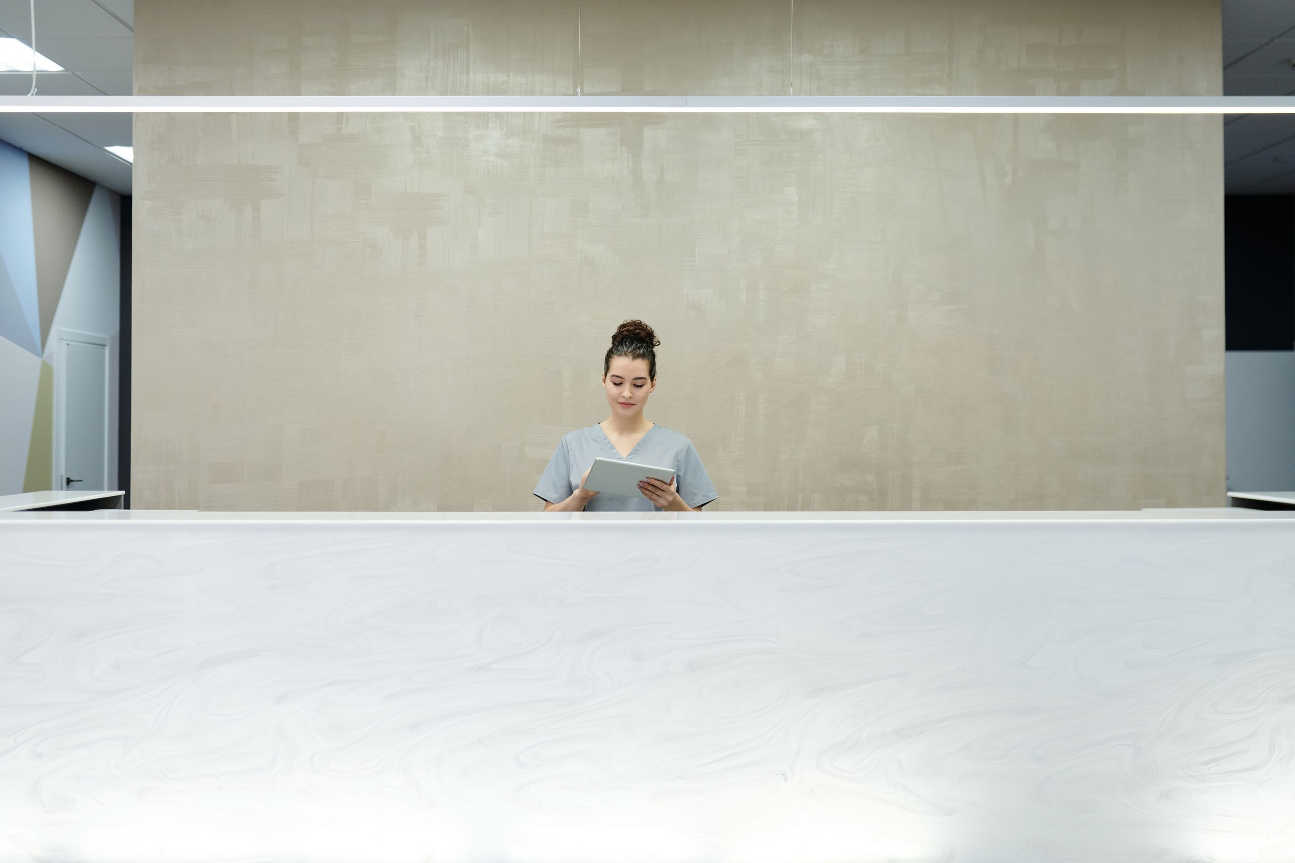 A staff member at a front desk taking an enquiry